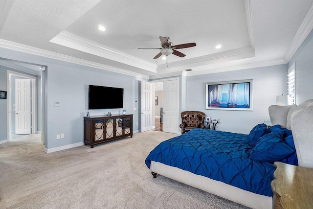 carpeted bedroom with ceiling fan, a raised ceiling, ornamental molding, and a textured ceiling