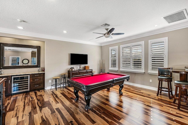 game room with light wood-type flooring, beverage cooler, crown molding, and billiards