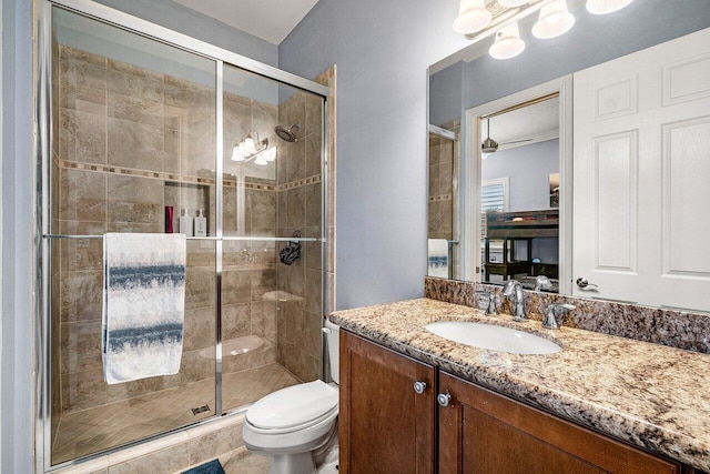 bathroom featuring vanity, toilet, and a shower with shower door