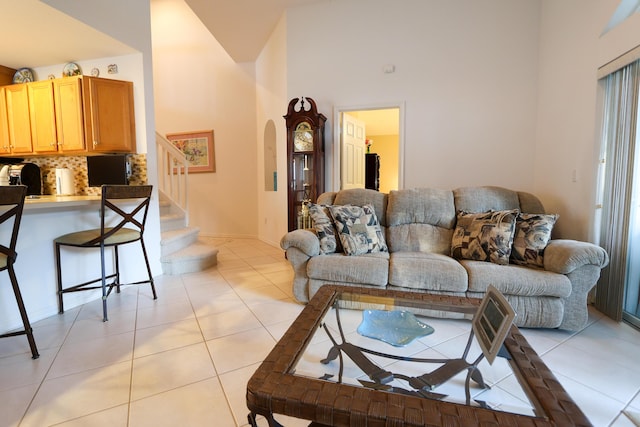 living room featuring light tile patterned floors and high vaulted ceiling