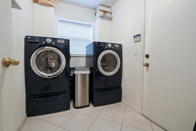 clothes washing area with washing machine and dryer and light tile patterned flooring