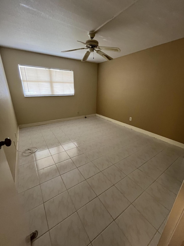 spare room featuring light tile patterned floors and ceiling fan