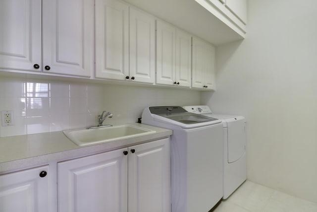 laundry area with cabinets, washer and clothes dryer, and sink