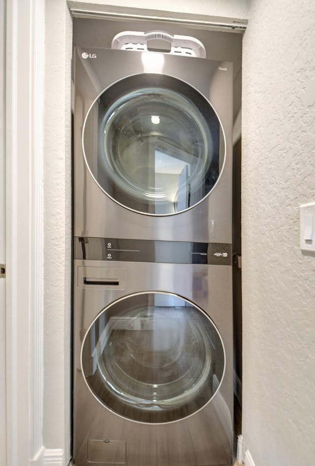 washroom featuring stacked washer / drying machine