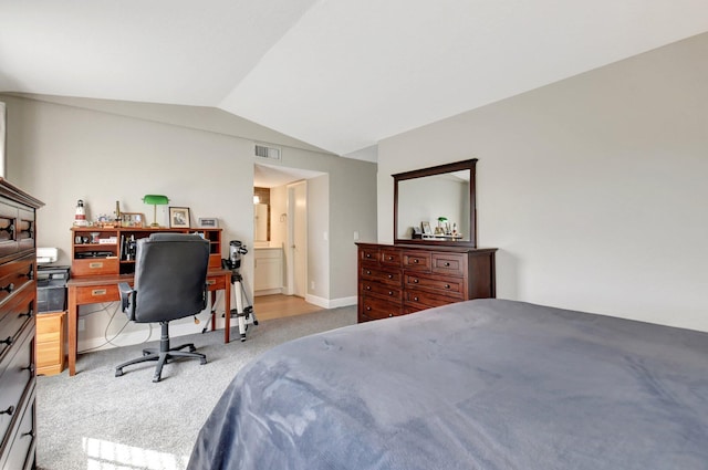 bedroom featuring connected bathroom, lofted ceiling, and light colored carpet