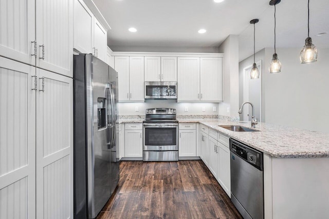 kitchen featuring pendant lighting, white cabinetry, sink, and appliances with stainless steel finishes