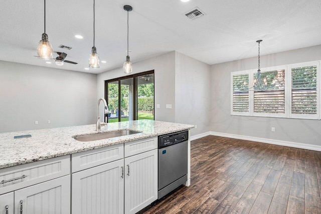 kitchen featuring light stone countertops, sink, stainless steel dishwasher, decorative light fixtures, and white cabinets