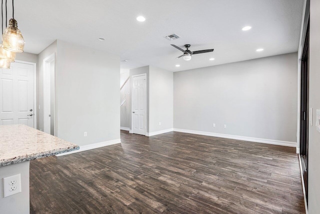 unfurnished living room with a textured ceiling, ceiling fan, and dark wood-type flooring