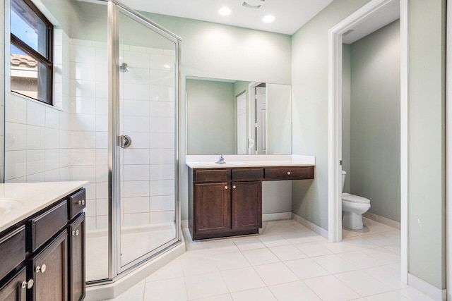 bathroom featuring tile patterned floors, vanity, an enclosed shower, and toilet