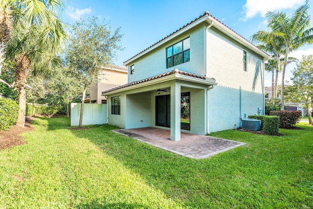 rear view of house featuring a lawn, a patio area, and central air condition unit