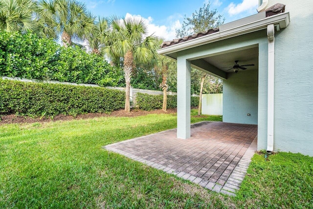 view of yard with ceiling fan and a patio