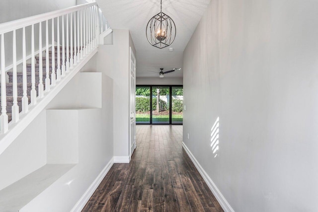 hallway featuring a chandelier, dark hardwood / wood-style flooring, and a textured ceiling