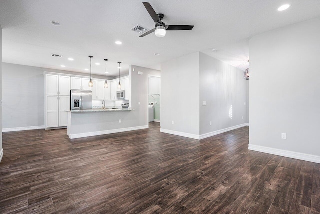 unfurnished living room with a textured ceiling, ceiling fan, dark wood-type flooring, and sink