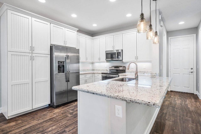 kitchen with white cabinetry, sink, stainless steel appliances, dark hardwood / wood-style flooring, and pendant lighting