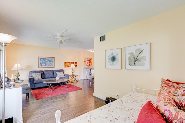 living room with ceiling fan and dark wood-type flooring