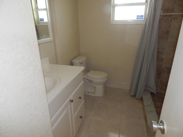 bathroom with tile patterned flooring, a shower with curtain, vanity, and toilet