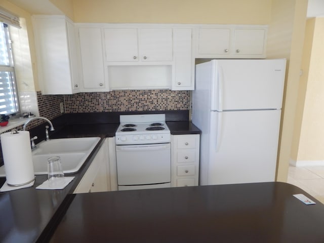 kitchen featuring tasteful backsplash, sink, white cabinets, and white appliances