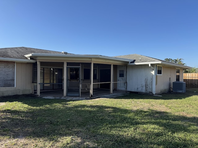 rear view of house featuring central AC, a sunroom, and a yard