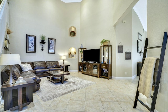 living room with light tile patterned floors and a towering ceiling