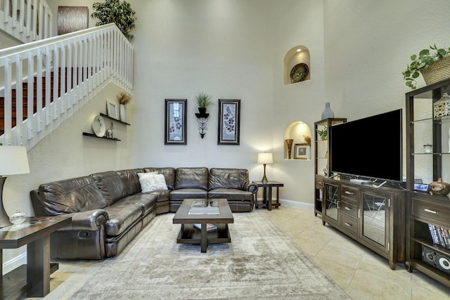 living room with a high ceiling and light tile patterned floors