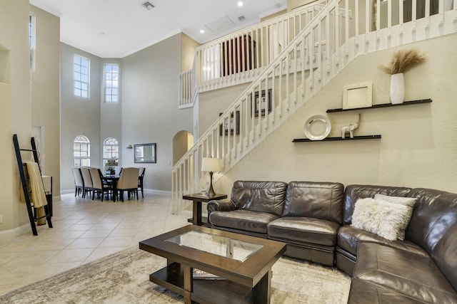 tiled living room with a towering ceiling and crown molding