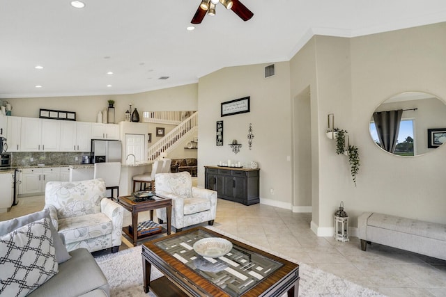 living room with lofted ceiling, light tile patterned floors, ceiling fan, and crown molding