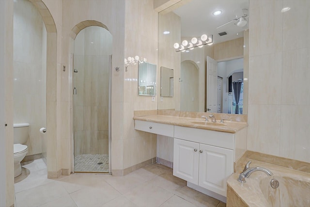 full bathroom with toilet, vanity, tile walls, tile patterned floors, and shower with separate bathtub