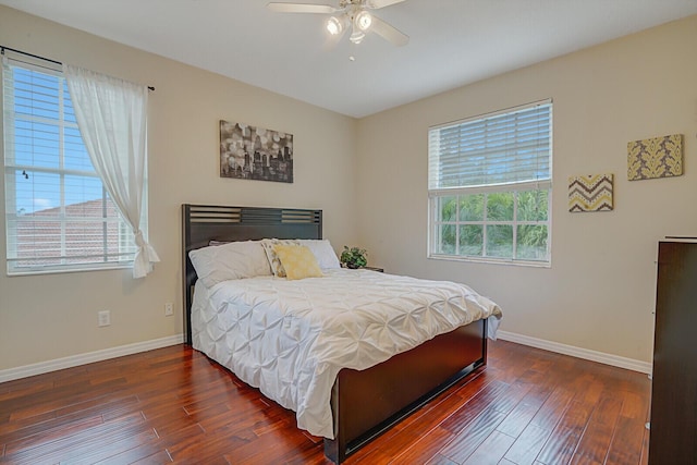 bedroom with ceiling fan, dark hardwood / wood-style floors, and multiple windows