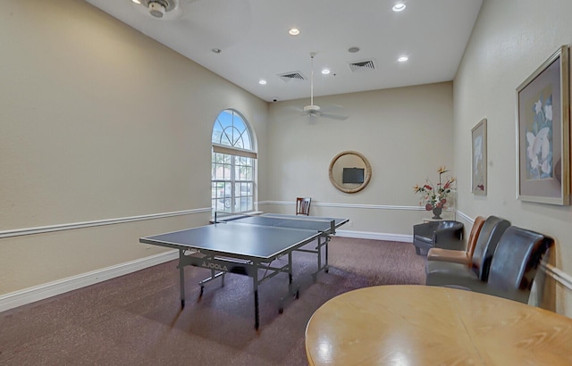 recreation room with ceiling fan and dark carpet