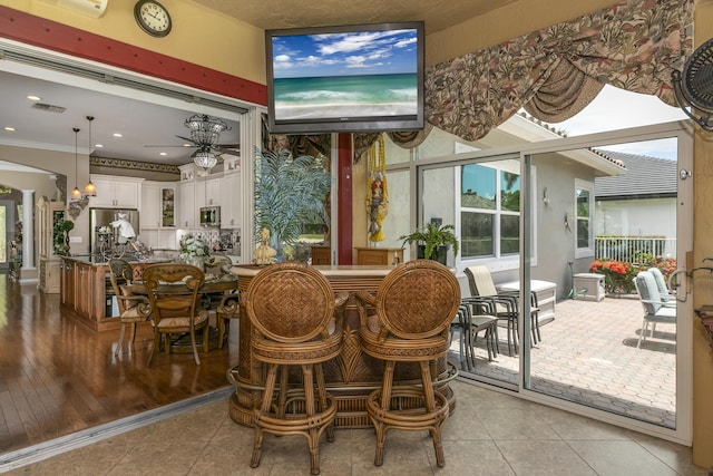 dining room featuring ceiling fan, light tile patterned floors, and crown molding