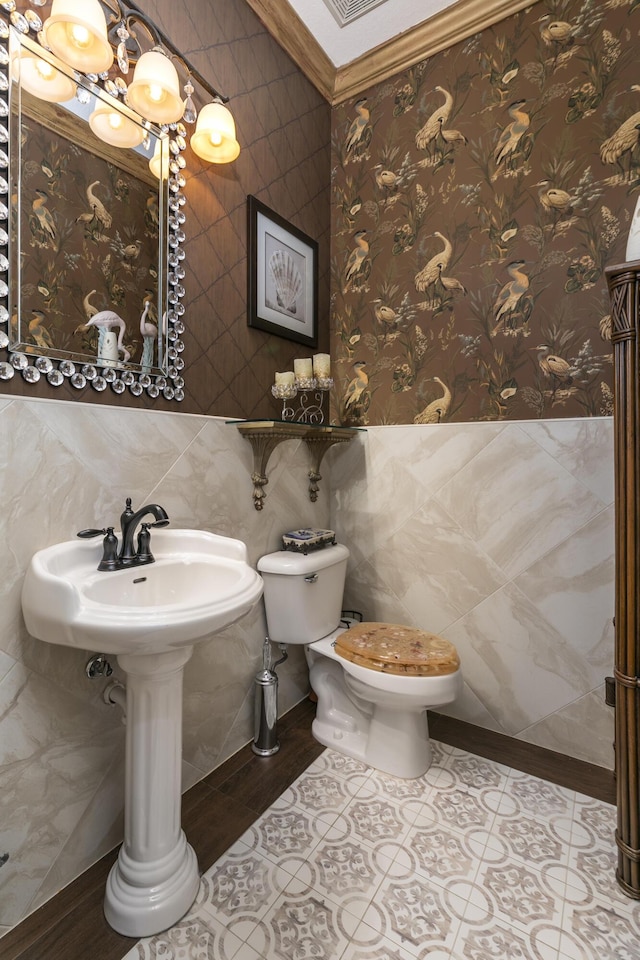 bathroom with tile patterned flooring, toilet, and tile walls