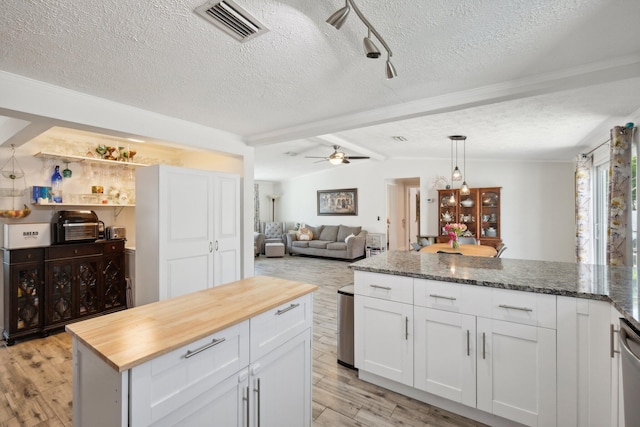 kitchen featuring white cabinetry, a center island, ceiling fan, light hardwood / wood-style flooring, and wooden counters