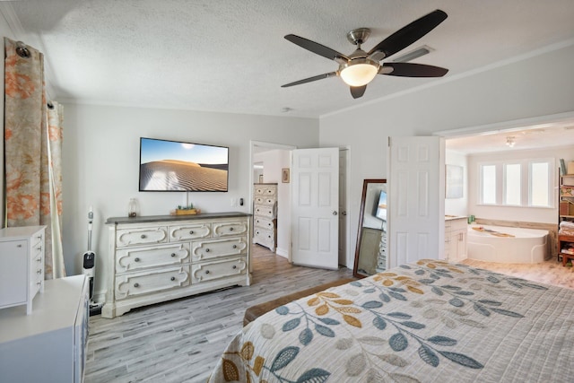 bedroom featuring lofted ceiling, ensuite bathroom, light hardwood / wood-style flooring, ceiling fan, and ornamental molding