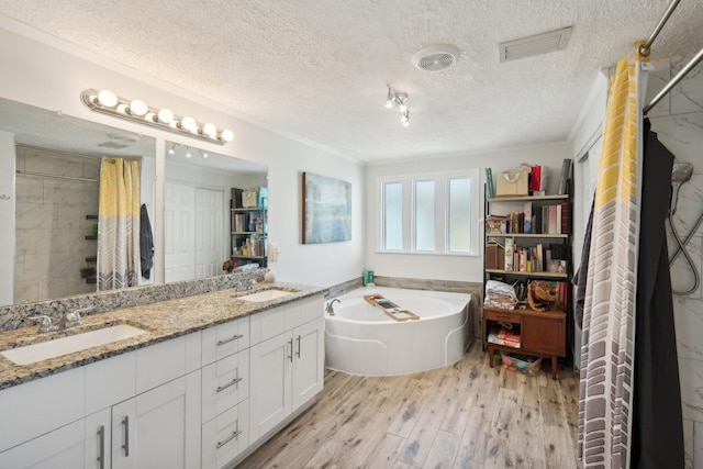 bathroom featuring hardwood / wood-style floors, ornamental molding, a textured ceiling, and independent shower and bath