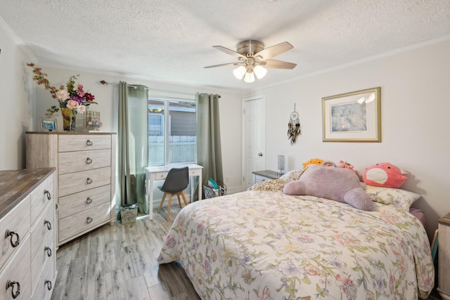 bedroom featuring ceiling fan, light wood-type flooring, a textured ceiling, and ornamental molding