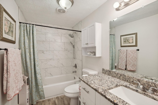 full bathroom with vanity, shower / bath combination with curtain, a textured ceiling, and toilet