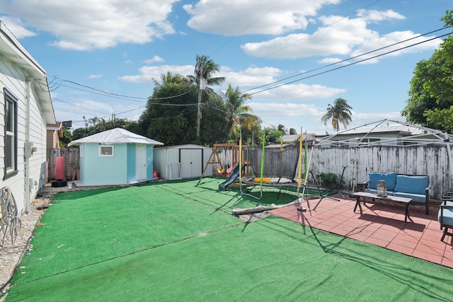 view of patio with a playground and a storage shed