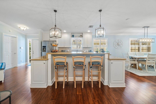 kitchen featuring stainless steel fridge, tasteful backsplash, visible vents, dark wood-style flooring, and a chandelier