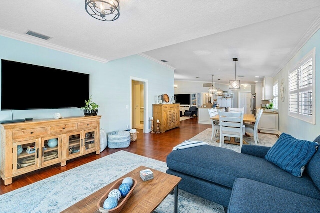 living room with dark wood-type flooring, a textured ceiling, and crown molding