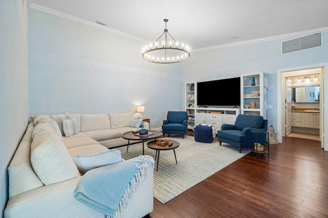 living room featuring a chandelier, crown molding, and wood-type flooring