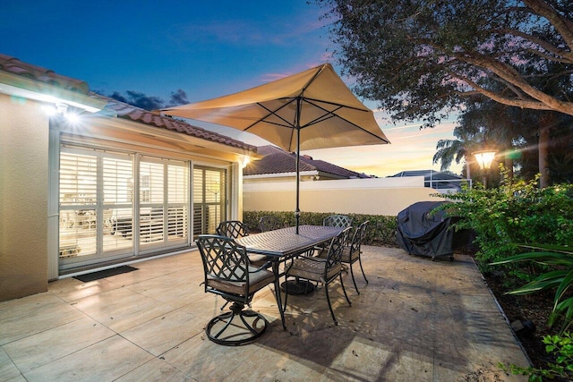 patio terrace at dusk featuring grilling area