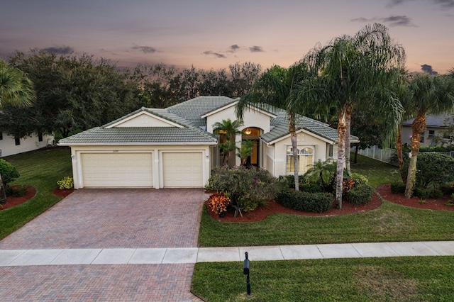 view of front facade with a garage and a lawn