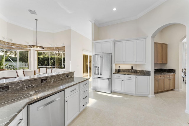 kitchen featuring stainless steel appliances, hanging light fixtures, light tile patterned floors, and white cabinets