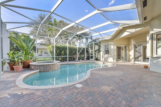 view of swimming pool featuring an in ground hot tub, glass enclosure, and a patio area