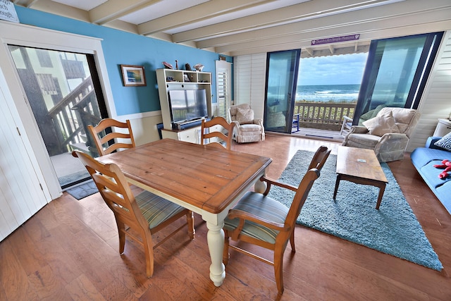 dining area featuring beam ceiling and hardwood / wood-style floors