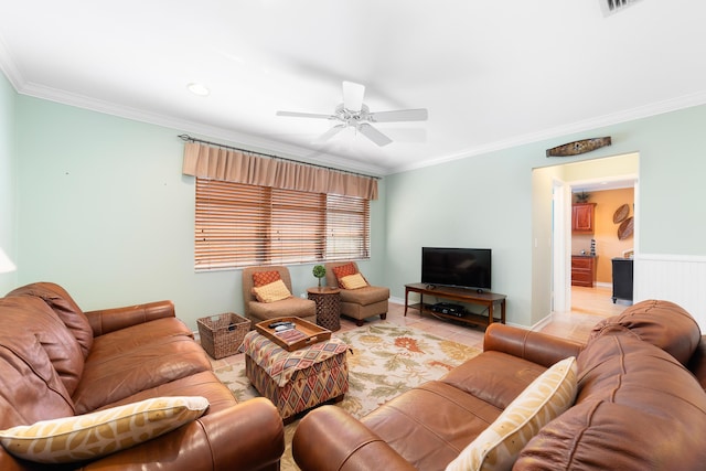 tiled living room with ceiling fan and ornamental molding