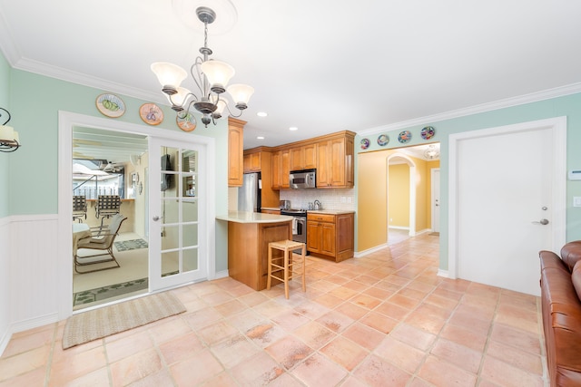 kitchen with a breakfast bar area, stainless steel appliances, tasteful backsplash, a notable chandelier, and pendant lighting