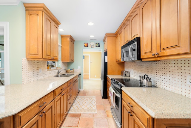 kitchen featuring sink, light stone counters, and stainless steel appliances