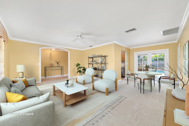 carpeted living room with ceiling fan and crown molding