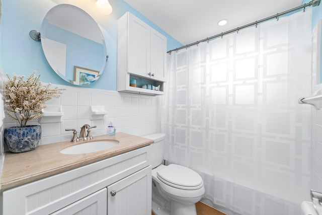 bathroom featuring toilet, tile walls, and vanity